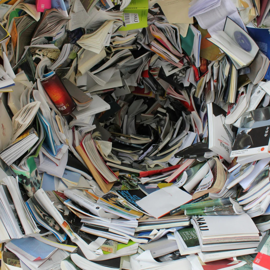 A spiral vortex made entirely of books, viewed from above—symbolizing the sensory overwhelm, saturation, and visual chaos often experienced by neurodivergent individuals.